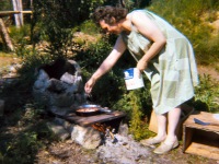 1969 Mama Lorene cooking breakfast on outdoor stove.