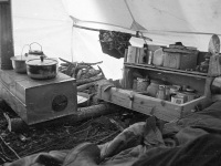 Oliver's wood stove in tent, grub box. Manley